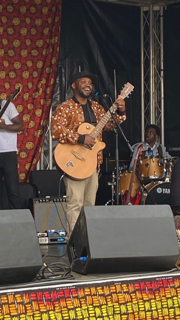 Hekima on stage playing a guitar.
